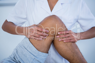 Mid section of physiotherapist giving leg massage to a patient