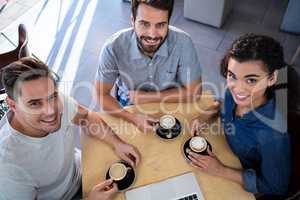 Portrait of smiling friends sitting at a table