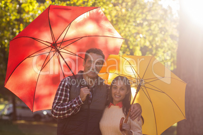 Portrait of couple holding umbrellas