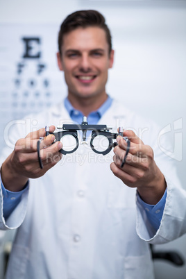 Smiling optometrist holding messbrille