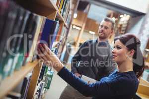 Mature student removing book from shelf