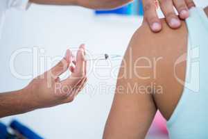 Physiotherapist injecting female patient