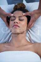 Woman receiving head massage from physiotherapist