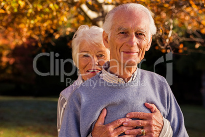 Senior couple embracing with the woman behind