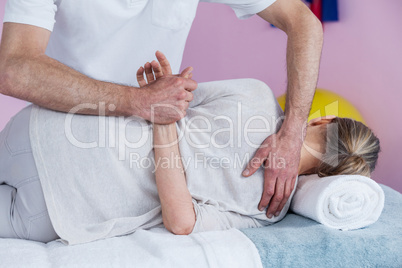 Physiotherapist massaging a senior womans shoulder