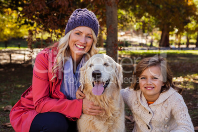 Mother and daughter caressing their dog