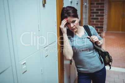 Stressed mature student standing in locker room