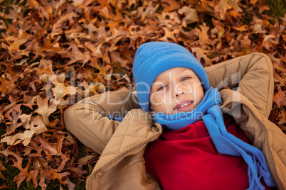 High angle portrait of boy lying at park during autumn