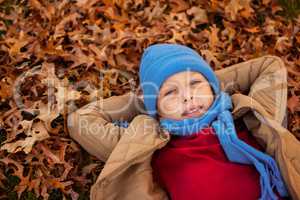 High angle portrait of boy lying at park during autumn