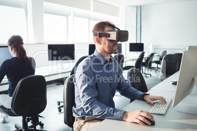 Mature student in virtual reality headset using computer