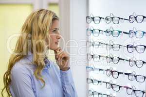 Thoughtful female customer selecting spectacles