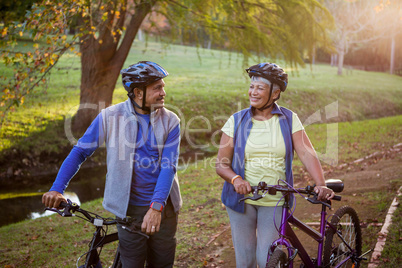 Mature couple walking with their bike