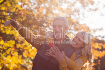 Joyful couple against trees at park