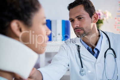Physiotherapist examining a female patients neck
