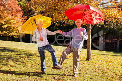 Senior couple dancing with umbrellas