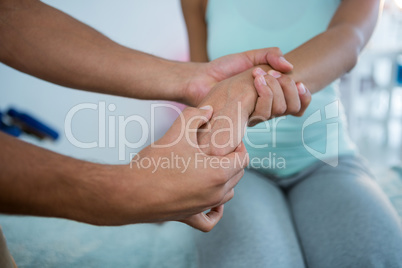 Physiotherapist giving hand massage to a woman