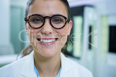 Optometrist in spectacles smiling in optical store