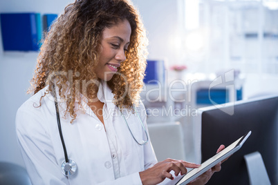 Smiling physiotherapist using digital tablet