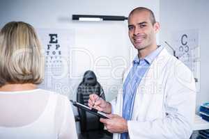 Male optometrist taking eye test of female patient