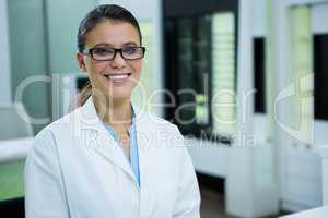 Optometrist in spectacles smiling in optical store