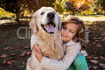 Little girl embracing her dog