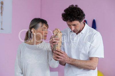 Physiotherapist examining a senior womans wrist