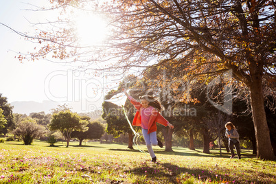 Girl holding kite while running at park
