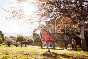 Girl holding kite while running at park