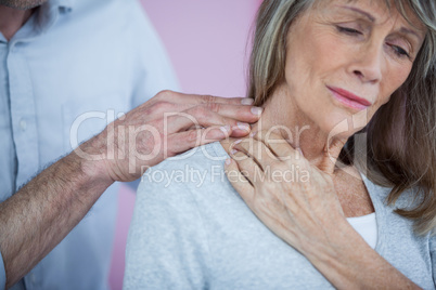 Physiotherapist giving neck massage to female patient