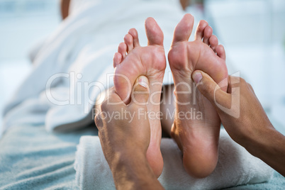 Physiotherapist giving foot massage to a woman