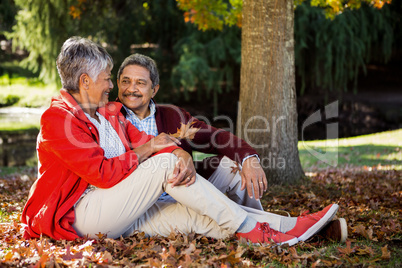 Couple relaxing at park during autumn