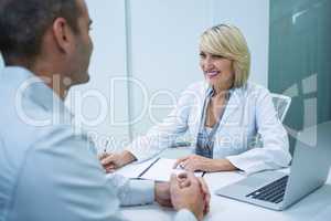 Female optometrist talking to male patient