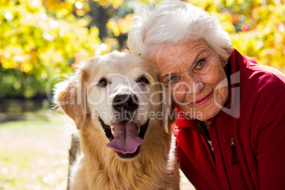 Portrait of elderly woman sitting with dog
