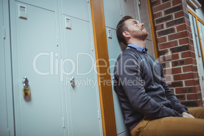 Stressed mature student sitting in locker room