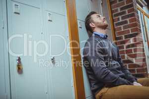 Stressed mature student sitting in locker room