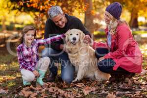 Smiling family with dog at park
