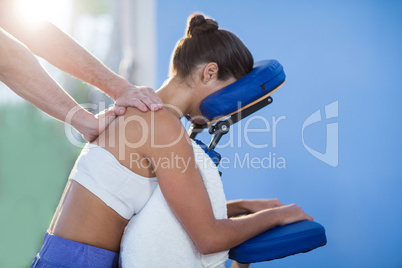 Physiotherapist giving shoulder massage to a female patient