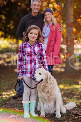 Daughter with parents standing at park during autumn