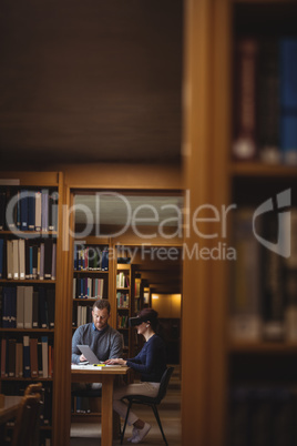 Mature students working together in college library