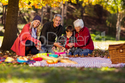 Happy family sitting at park during autumn