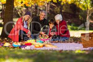 Happy family sitting at park during autumn