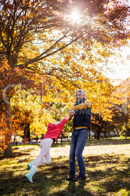 Father playing with daughter at park