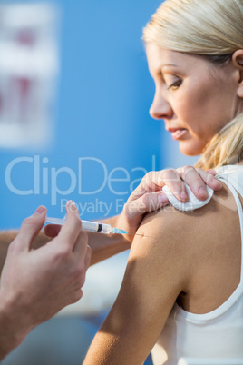 Physiotherapist injecting female patient Physiotherapist injecting female patient