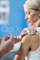 Physiotherapist injecting female patient