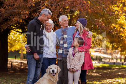 Family standing with dog at park