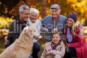 Cheerful multi-generation family with dog at park