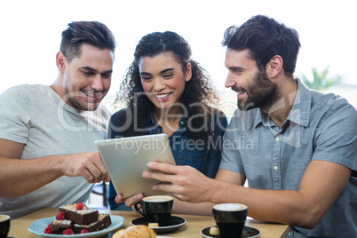 Three friends using a digital tablet