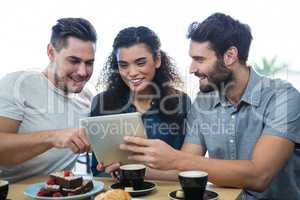 Three friends using a digital tablet