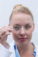 Female optometrist looking through magnifying glass