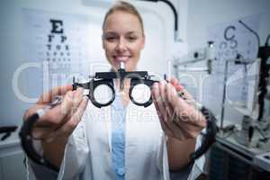 Smiling female optometrist holding messbrille